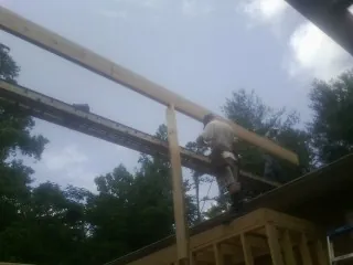 Carpenter setting a ridge beam over a new addition frame — Ice Dam Removal by Roofing Brothers in Wartburg