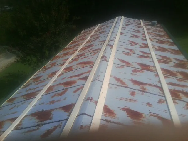 Rusted metal roof panels with new wood purlins before replacement — Storm Damage Roof Repair in Wartburg by Roofing Brothers